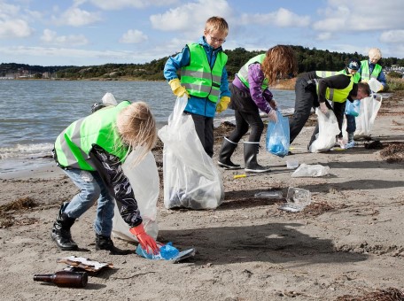 a group of people cleaning up trash on a beach