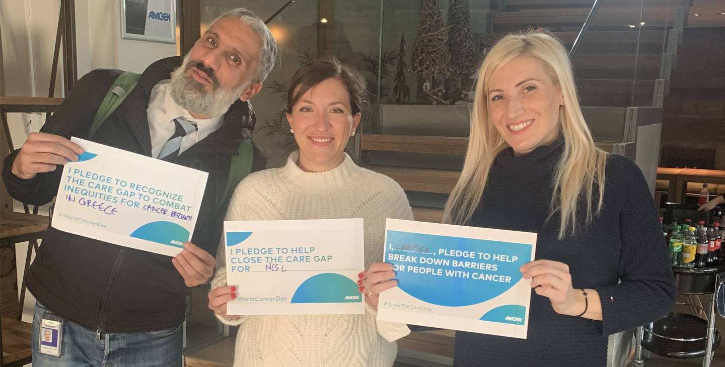 Three people smiling and holding a paper