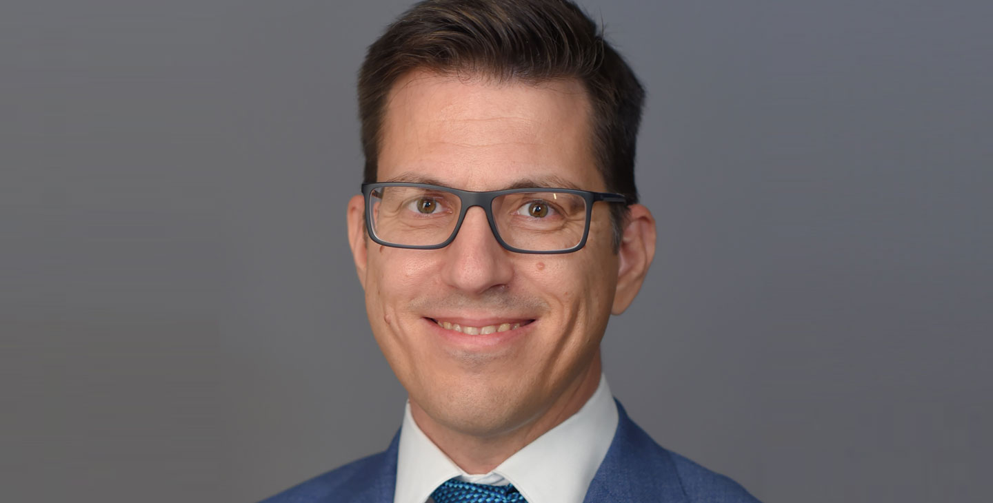 a person in a suit smiling at the camera