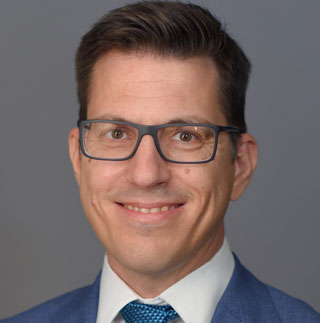 a person in a suit smiling at the camera