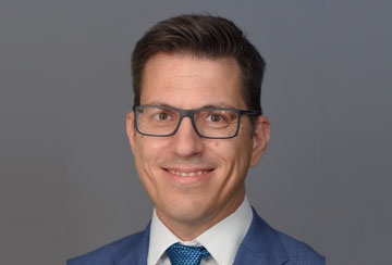 a person in a suit smiling at the camera